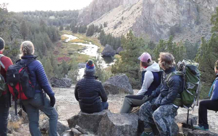 a group of students observe a river below before embarking on a rafting expedition 